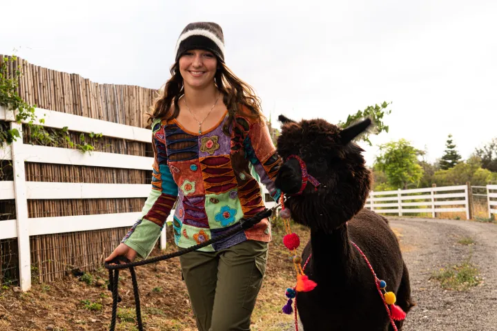 Kate Madison holding a little girl standing next to a fence